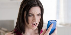 Fotografie ženy, která se mračila na mobilní telefon