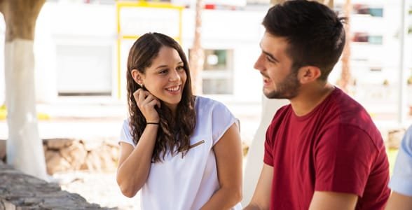 Photo d'une fille touchant son cou en parlant à un gars