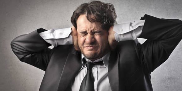 Photo d'un homme se couvrant les oreilles