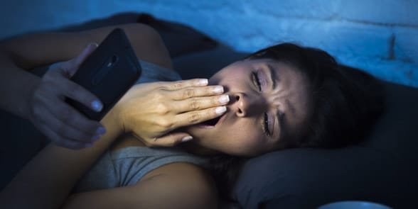 Foto einer Frau, die spät eine SMS schreibt