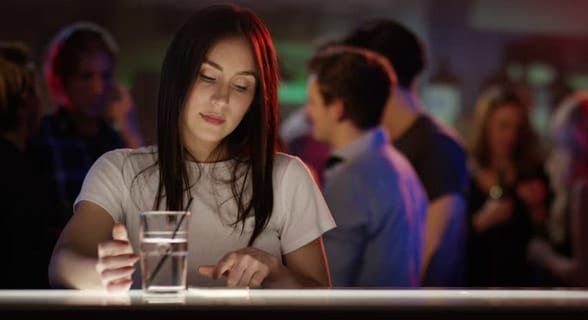 Foto van een vrouw alleen in een bar