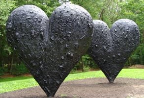 Photo de deux grands cœurs noirs sculptés par Jim Dine