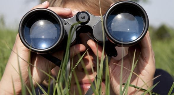 Foto di una donna che guarda attraverso il binocolo