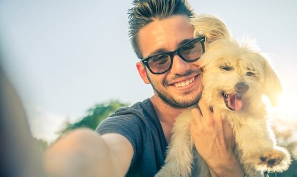 Photo d'un homme prenant un selfie avec un chien