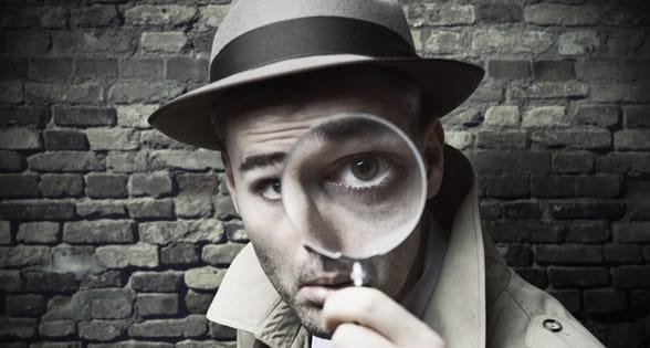 Foto van een man die door een vergrootglas kijkt