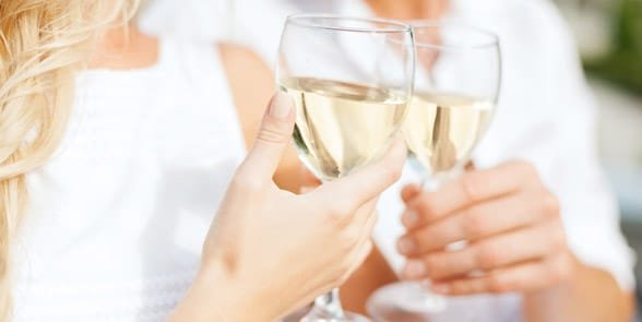 Foto di una coppia che fa tintinnare i bicchieri di vino