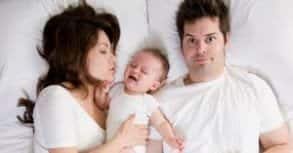 Foto von Paar im Bett mit Baby