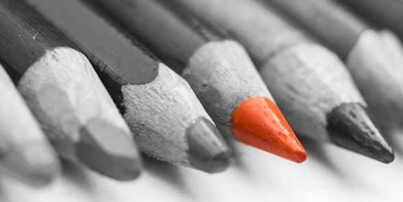 Photo d'un crayon rouge dans un groupe de crayons noirs