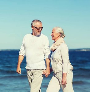 Foto van een senior koppel dat op het strand loopt