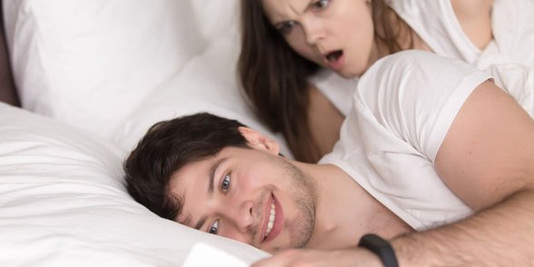 Foto van een vrouw die over de schouder van haar vriend kijkt