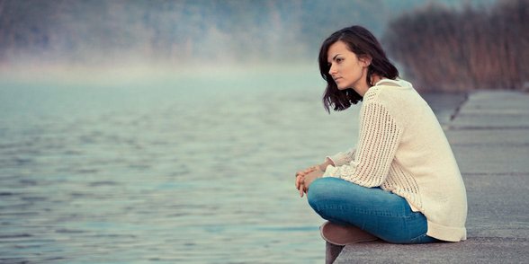Foto einer Frau auf einem Dock, die nachdenkt