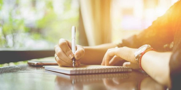 Foto de hombre escribiendo en un cuaderno