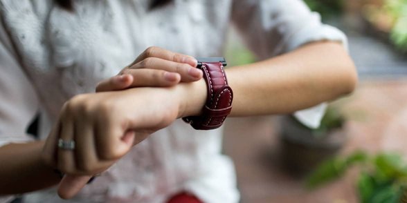 Foto van vrouw die naar horloge kijkt