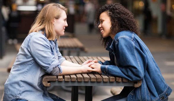 Foto di due donne protese l'una verso l'altra