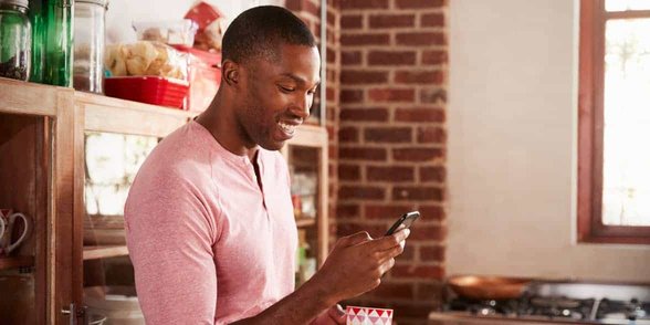 Photo d'un homme qui envoie des SMS sur son téléphone